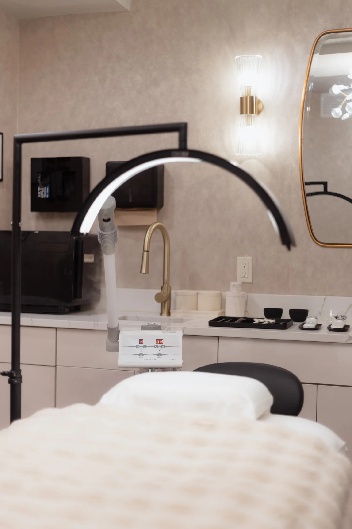 A private AgeSculpt treatment room at Skin Sculptor Studio in Manhattan, with the arched sculpting device beside a warm ivory vanity.